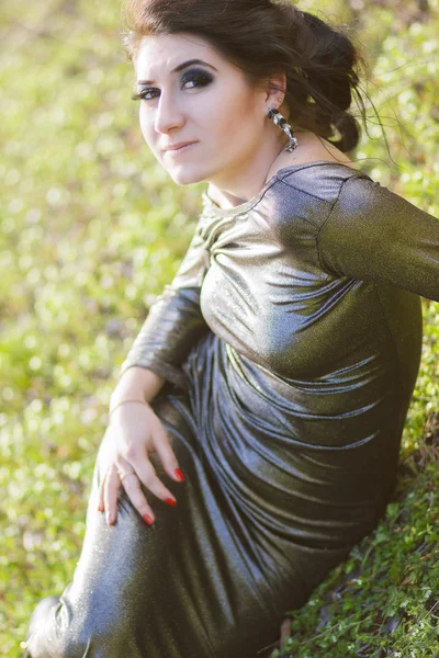 Luxury woman in a long black evening dress in the park — Stock Photo, Image