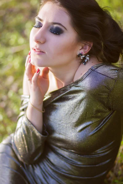 Luxury woman in a long black evening dress in the park — Stock Photo, Image