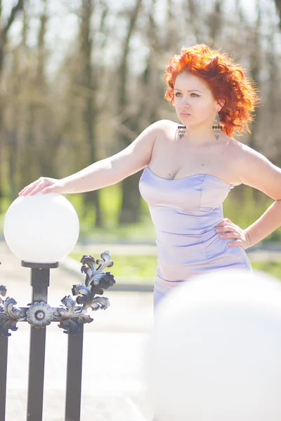 Prachtige roodharige vrouw op een wandeling in het park. jong meisje over de aard — Stockfoto