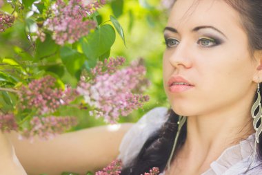 güzel genç esmer doğada poz. saç ve makyaj romantik beyaz elbiseli kız