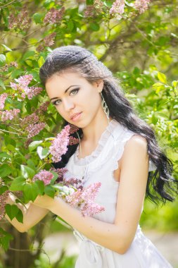 güzel genç esmer doğada poz. saç ve makyaj romantik beyaz elbiseli kız