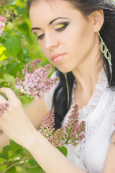 Beautiful young brunette posing in nature. Girl with hair and makeup in white romantic dress — Stock Photo, Image