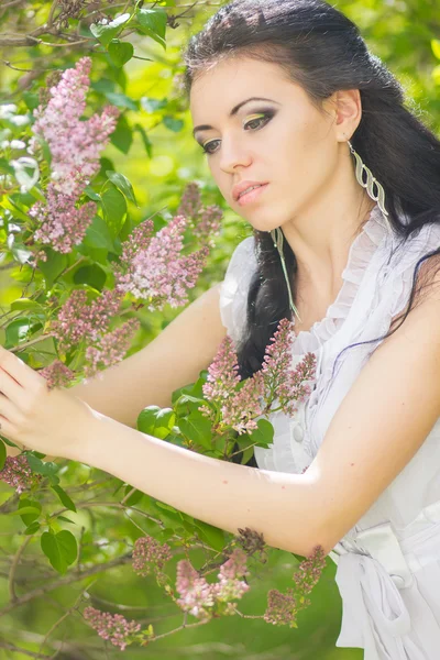 Güzel genç esmer doğada poz. saç ve makyaj romantik beyaz elbiseli kız — Stok fotoğraf