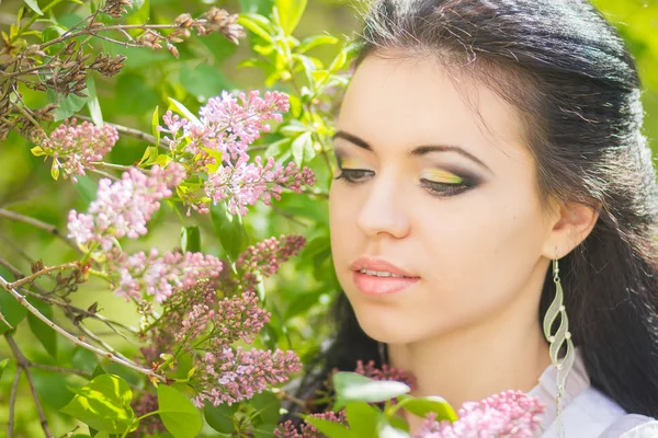 Linda jovem morena posando na natureza. Menina com cabelo e maquiagem em vestido romântico branco — Fotografia de Stock