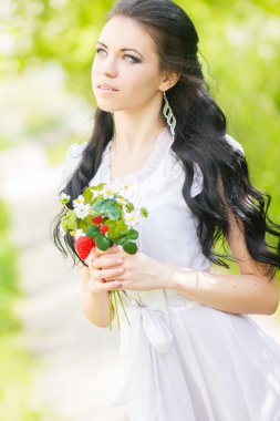 güzel genç esmer doğada poz. saç ve makyaj romantik beyaz elbiseli kız