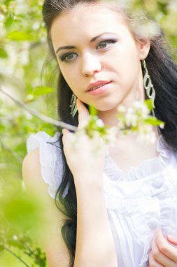 güzel genç esmer doğada poz. saç ve makyaj romantik beyaz elbiseli kız