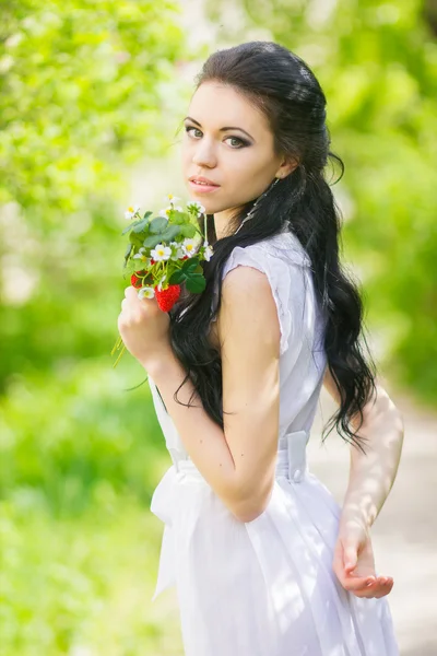 Belle jeune brune posant dans la nature. Fille avec les cheveux et le maquillage en robe romantique blanche — Photo