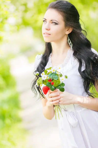 Belle jeune brune posant dans la nature. Fille avec les cheveux et le maquillage en robe romantique blanche — Photo