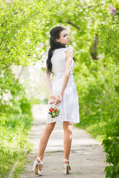 Beautiful young brunette posing in nature. Girl with hair and makeup in white romantic dress Royalty Free Stock Photos