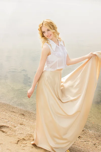 Retrato de una hermosa joven rubia con el pelo ondulado en la naturaleza — Foto de Stock