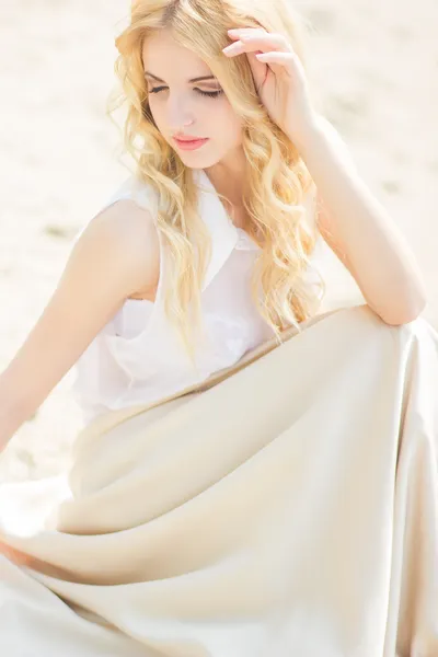 Portret van een mooie jonge blonde vrouw met golvend haar in de natuur — Stockfoto