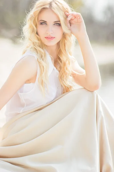 Portret van een mooie jonge blonde vrouw met golvend haar in de natuur — Stockfoto