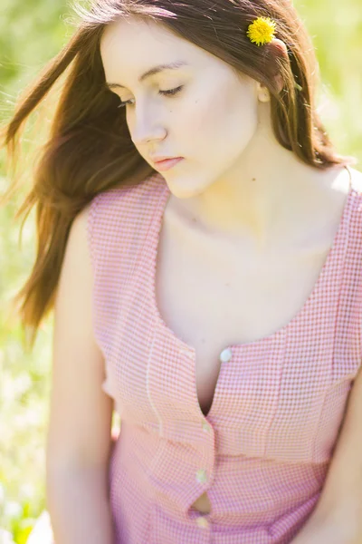 Retrato de uma bela jovem com cabelo castanho em vestido xadrez retro. Menina posando na natureza com um pequeno buquê de violetas — Fotografia de Stock