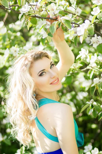 doğada yüksek bir yarık ile mavi uzun elbise uzun saçlı güzel bir genç sarışın kadın portresi.