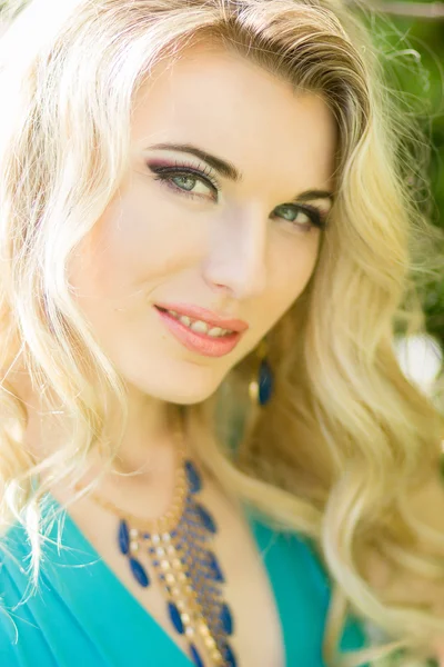 Portret pięknej młodej kobiety blondynka z długimi włosami w niebieska suknia z wysokiej szczeliny w przyrodzie. — Zdjęcie stockowe