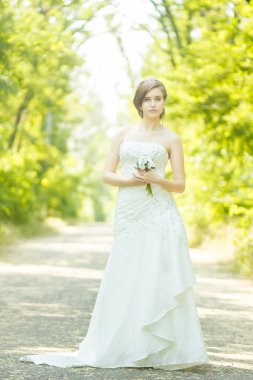 doğa çok güzel bir genç gelin portresi. genç bir kadın onun elinde tutan küçük bir beyaz gül buketi