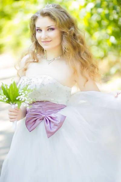 Porträt einer schönen jungen Braut in der Natur in einem prachtvollen Brautkleid. — Stockfoto