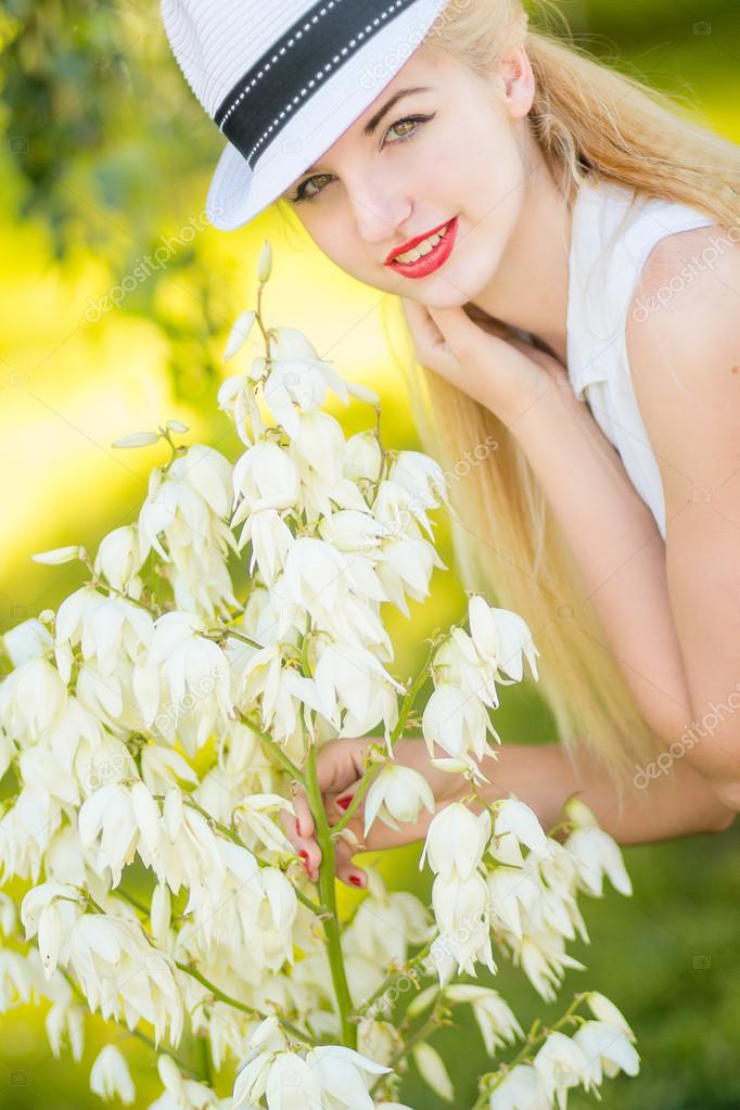 Outdoor summer portrait of young pretty cute blonde girl. Beautiful woman posing in the park