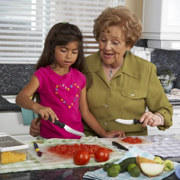 Hispanic grandmother and granddaughter preparing food