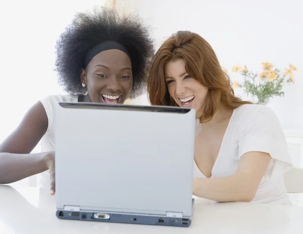 Two women looking at laptop and laughing