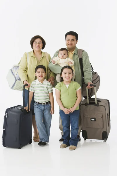 Portrait of multi-ethnic family with suitcases
