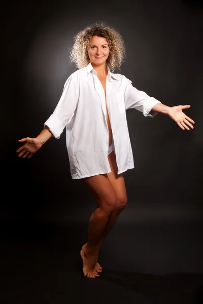 Mature woman dancing against black background — Stock Photo, Image