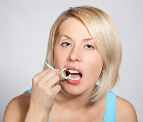 Mulher loira positiva verifica os dentes — Fotografia de Stock