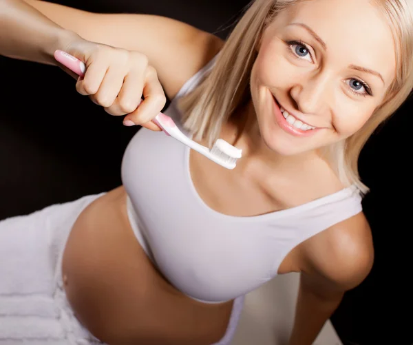 Pozitivní těhotná blondýna kontroluje její zuby Stock Obrázky