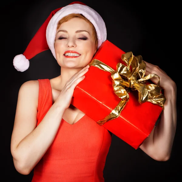 Mulher usando chapéu de Papai Noel segurando presente de Natal — Fotografia de Stock