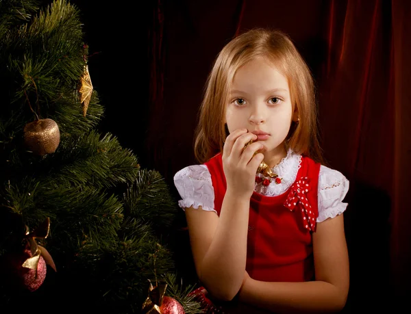 Sorrowful little girl near Christmas tree — Stock Photo, Image