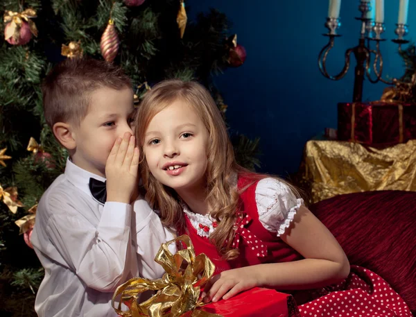 Ragazzino e ragazza vicino all'albero di Natale e regali — Foto Stock