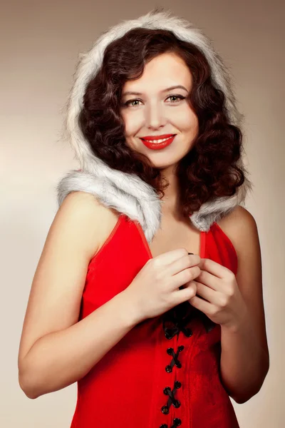 Noel Baba kız doğru kamera üzerinde kırmızı bir arka plan — Stok fotoğraf