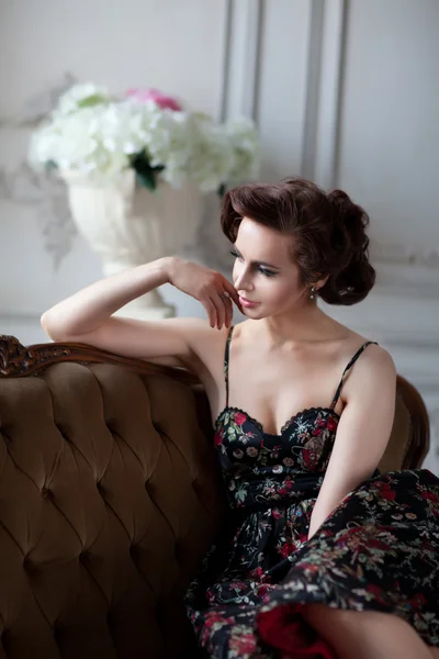 Donna attraente seduta su un divano — Foto Stock
