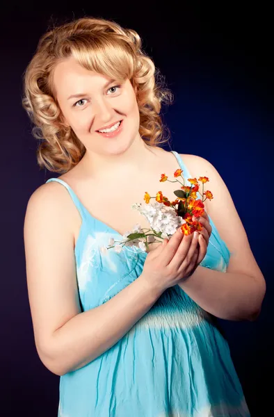 Beautiful female model wearing blue dress on dark background — Stock Photo, Image