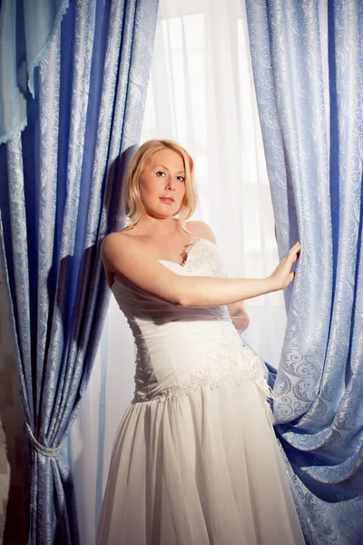 Vackra gravid brud poserar mot fönster — Stockfoto
