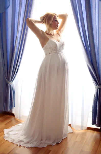 Krásná těhotná nevěsta vystupují proti okno — Stock fotografie