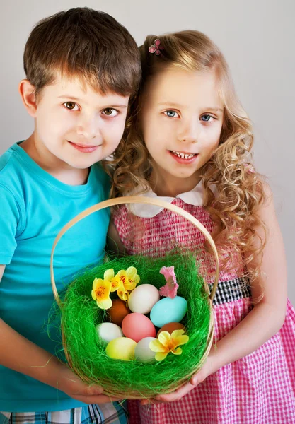 GIrl and boy wearing as Easter Rabbit sitting on the grass — Stock Photo, Image