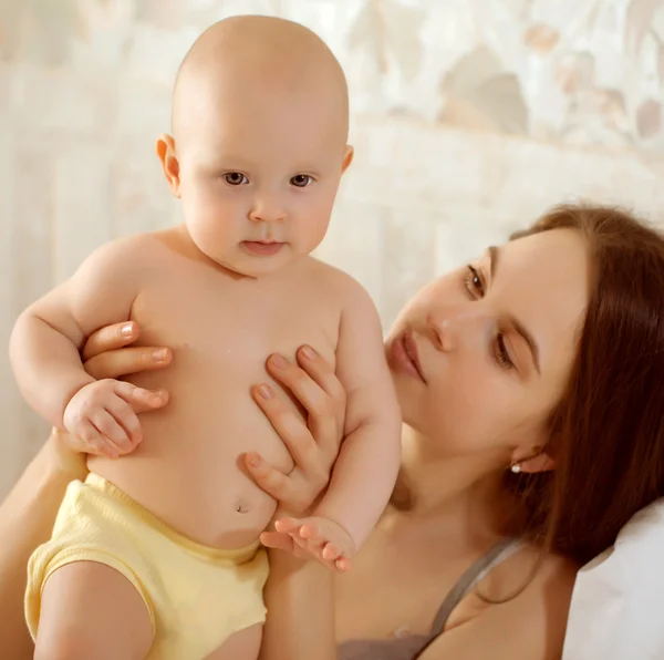 Gelukkig uitziende baby dragen breien hoed en moeder spelen toget — Stockfoto