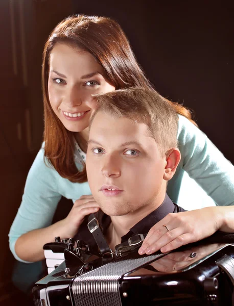 Muzikant speelt de accordeon tegen een donkere achtergrond — Stockfoto