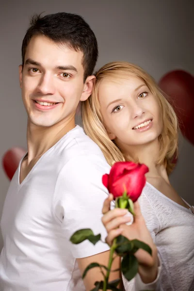 Young couple of lovers. Man presents flower — Stock Photo, Image