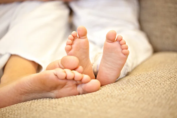 Mother s and baby s feet as a concept of motherhood or maternity — Stock Photo, Image