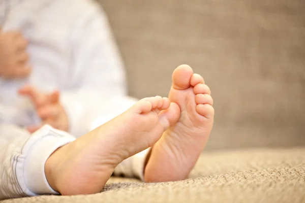 Foot of baby sitting on the wooden banisters — Stock Photo, Image