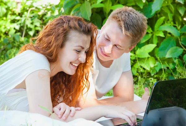 YOung casal com computador no parque se divertindo — Fotografia de Stock