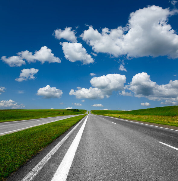 Landscape with road and cloudy blue sky