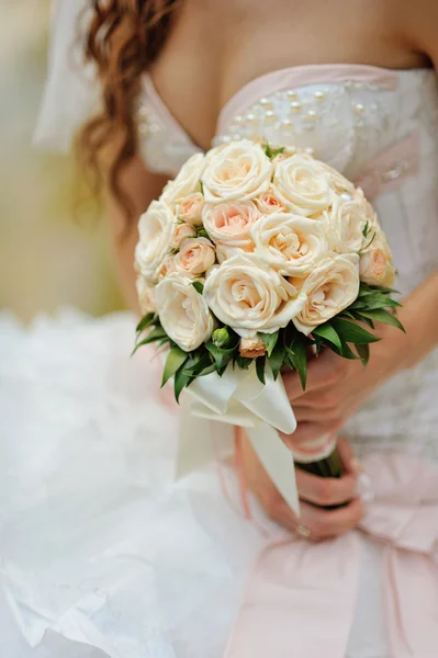 Mariée tient un bouquet de roses de mariage — Photo