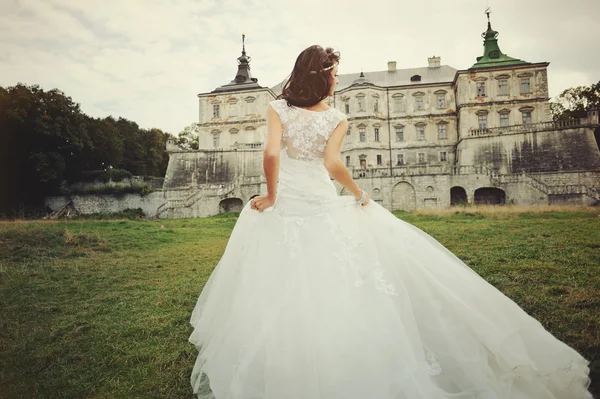 Gyönyörű menyasszony séta a kastély mellett Stock Kép