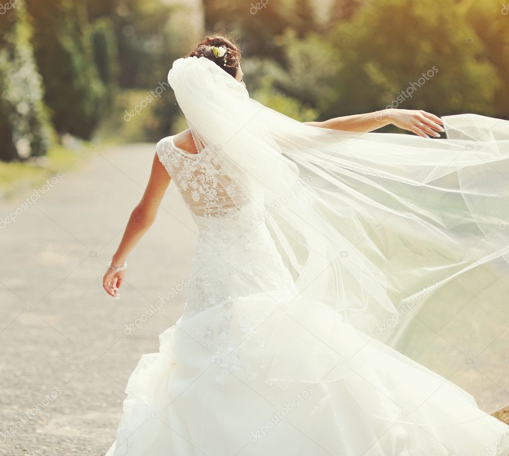 happy brunette bride spinning around with veil