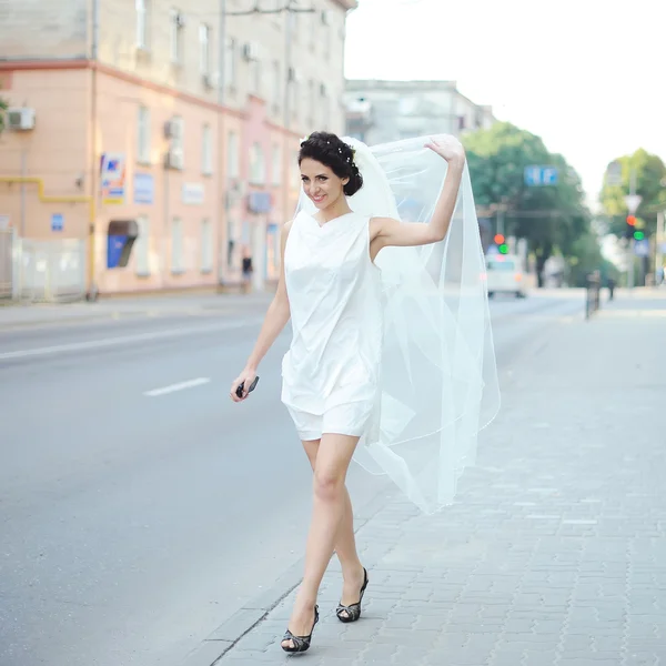 Beautiful bride with veil walking street