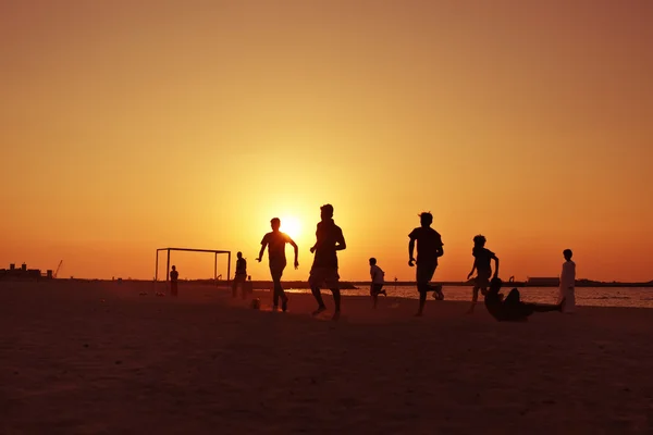 Futebol na praia em Dubai durante o pôr do sol . — Fotografia de Stock