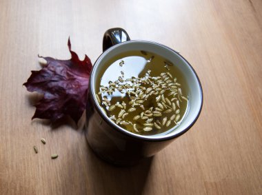 Cup of fennel tea with seeds. clipart